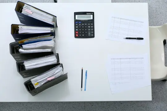 segregatory z dokumentami na biurku księgowej